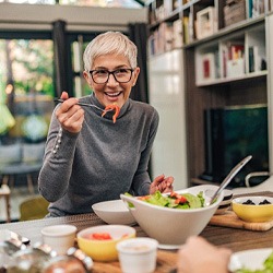 Woman smiling while eating healthy meal with friend