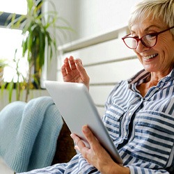 Woman smiling while using tablet at home