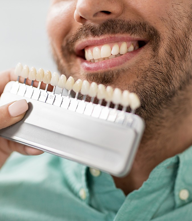 A dentist assessing the shade of a man’s smile