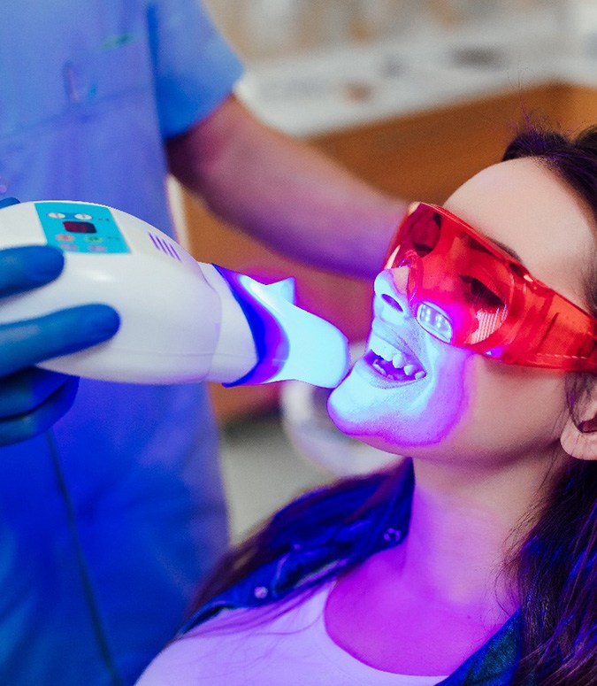 A dentist bleaching a woman’s teeth